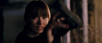 Movie still from “Deadfall” (2012), directed by Stefan Ruzowitzky – A woman is holding a gun in her hand; Close Up shot, Over the shoulder angle