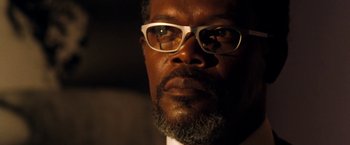 Movie still from “Deep Blue Sea” (1999), directed by Renny Harlin – A person wearing glasses and a suit; Close Up shot, Low angle