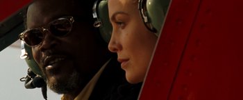 Movie still from “Deep Blue Sea” (1999), directed by Renny Harlin – A woman wearing ear muffs sitting in an airplane cockpit; Close Up shot, Low angle