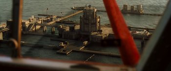 Movie still from “Deep Blue Sea” (1999), directed by Renny Harlin – An aerial view of an island with a tower and a pier; Extreme Wide shot, High angle