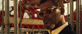 Movie still from “Deep Blue Sea” (1999), directed by Renny Harlin – A person wearing sunglasses near a chain link fence; Close Up shot, Low angle