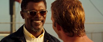 Movie still from “Deep Blue Sea” (1999), directed by Renny Harlin – A man wearing sunglasses and a jacket talking to another man; Close Up shot, Over the shoulder angle