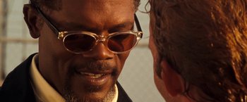 Movie still from “Deep Blue Sea” (1999), directed by Renny Harlin – A person wearing glasses and a suit; Close Up shot, Over the shoulder angle