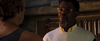 Movie still from “Deep Blue Sea” (1999), directed by Renny Harlin – A person wearing glasses and a sweater; Close Up shot, Over the shoulder angle