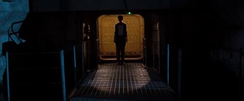 Movie still from “Deep Blue Sea” (1999), directed by Renny Harlin – A person standing in a tunnel with a green light; Wide shot, Low angle