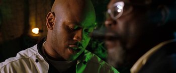 Movie still from “Deep Blue Sea” (1999), directed by Renny Harlin – A man with a bald head is looking at a man with glasses; Close Up shot, Low angle