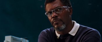 Movie still from “Deep Blue Sea” (1999), directed by Renny Harlin – A person wearing glasses and a suit; Close Up shot, Low angle
