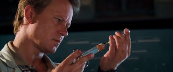 Movie still from “Deep Blue Sea” (1999), directed by Renny Harlin – A man holding an electronic device in his hands; Close Up shot, Low angle