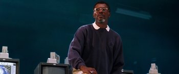 Movie still from “Deep Blue Sea” (1999), directed by Renny Harlin – A man standing in front of a television set; Medium shot, Low angle