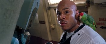 Movie still from “Deep Blue Sea” (1999), directed by Renny Harlin – A man with a bald head and a tie; Close Up shot, Low angle