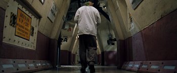Movie still from “Deep Blue Sea” (1999), directed by Renny Harlin – A man walking down the hallway of a train station; Wide shot, Low angle