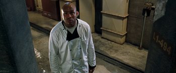 Movie still from “Deep Blue Sea” (1999), directed by Renny Harlin – A man standing in a room wearing a chef's outfit; Medium shot, Low angle