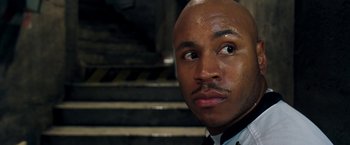 Movie still from “Deep Blue Sea” (1999), directed by Renny Harlin – A man with a bald head looking into the camera; Close Up shot, Low angle