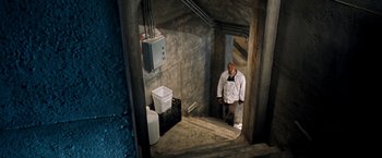 Movie still from “Deep Blue Sea” (1999), directed by Renny Harlin – A man standing inside of an unfinished building; Wide shot, Overhead angle