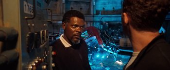 Movie still from “Deep Blue Sea” (1999), directed by Renny Harlin – A man standing next to a pile of machinery; Medium shot, Over the shoulder angle