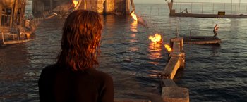 Movie still from “Deep Blue Sea” (1999), directed by Renny Harlin – A woman sitting in front of a body of water; Wide shot, Over the shoulder angle