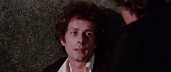 Movie still from “Deep Red” (1975), directed by Dario Argento – A person wearing a suit and tie; Close Up shot, High angle