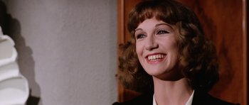 Movie still from “Deep Red” (1975), directed by Dario Argento – A person smiling; Close Up shot, Over the shoulder angle
