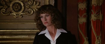 Movie still from “Deep Red” (1975), directed by Dario Argento – A person with curly hair wearing a suit; Close Up shot, Low angle