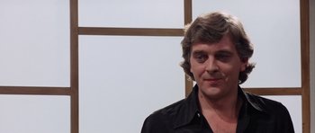 Movie still from “Deep Red” (1975), directed by Dario Argento – A person wearing a black shirt; Close Up shot, Over the shoulder angle