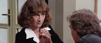 Movie still from “Deep Red” (1975), directed by Dario Argento – A woman holding her hand up to her face; Close Up shot, Over the shoulder angle