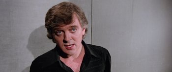 Movie still from “Deep Red” (1975), directed by Dario Argento – A person wearing a black shirt; Close Up shot, Low angle