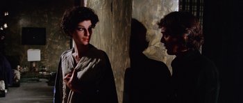 Movie still from “Deep Red” (1975), directed by Dario Argento – A man and a woman standing next to each other; Close Up shot, Over the shoulder angle