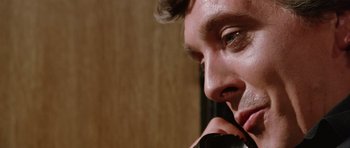Movie still from “Deep Red” (1975), directed by Dario Argento – A man's face while holding a cell phone to his ear; Extreme Close Up shot, Low angle