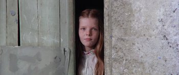 Movie still from “Deep Red” (1975), directed by Dario Argento – A young girl standing in the doorway of an old house; Close Up shot, High angle