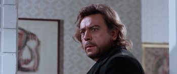 Movie still from “Deep Red” (1975), directed by Dario Argento – A person with long hair and a beard; Close Up shot, Low angle