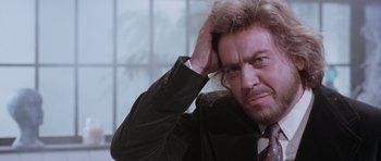 Movie still from “Deep Red” (1975), directed by Dario Argento – A person holding his hand to his head; Close Up shot, Over the shoulder angle