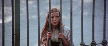 Movie still from “Deep Red” (1975), directed by Dario Argento – A young girl holding onto a metal fence; Close Up shot, High angle