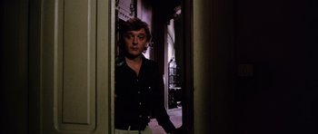 Movie still from “Deep Red” (1975), directed by Dario Argento – A man standing in the doorway of an old building; Medium shot, Low angle