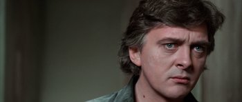 Movie still from “Deep Red” (1975), directed by Dario Argento – A person wearing a green shirt; Close Up shot, Over the shoulder angle