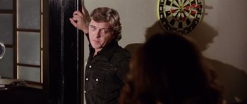 Movie still from “Deep Red” (1975), directed by Dario Argento – A man standing in front of a wall with a clock in the background; Medium shot, Over the shoulder angle