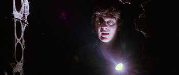 Movie still from “Deep Red” (1975), directed by Dario Argento – A man with a flashlight in a dark room; Close Up shot, Low angle