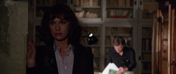 Movie still from “Deep Red” (1975), directed by Dario Argento – A woman standing in front of a book shelf; Medium shot, Over the shoulder angle
