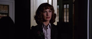 Movie still from “Deep Red” (1975), directed by Dario Argento – A woman in a black jacket and a white shirt; Close Up shot, Low angle