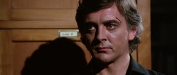Movie still from “Deep Red” (1975), directed by Dario Argento – A person wearing a black t - shirt; Close Up shot, Low angle