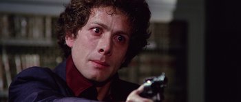 Movie still from “Deep Red” (1975), directed by Dario Argento – A person holding a gun; Close Up shot, Low angle