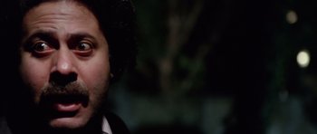 Movie still from “Deep Red” (1975), directed by Dario Argento – A person wearing a suit and tie; Close Up shot, Low angle