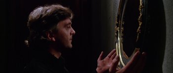 Movie still from “Deep Red” (1975), directed by Dario Argento – A man looking at himself in a mirror; Close Up shot, Over the shoulder angle