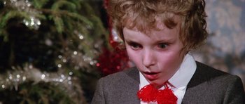 Movie still from “Deep Red” (1975), directed by Dario Argento – A young boy wearing a suit and red bow tie; Close Up shot, Over the shoulder angle