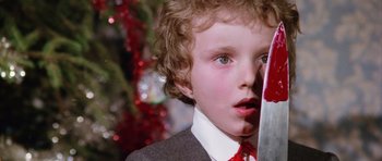Movie still from “Deep Red” (1975), directed by Dario Argento – A young boy wearing a suit and red tie; Close Up shot, Low angle