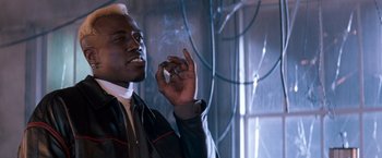 Movie still from “Demolition Man” (1993), directed by Marco Brambilla – A man smoking a cigarette in a room; Close Up shot, Low angle
