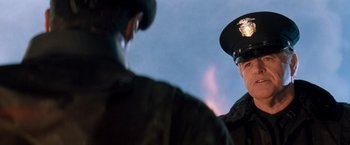 Movie still from “Demolition Man” (1993), directed by Marco Brambilla – Two men in military uniforms looking at each other; Close Up shot, Over the shoulder angle