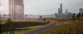 Movie still from “Demolition Man” (1993), directed by Marco Brambilla – A car driving down a road with palm trees in the background; Extreme Wide shot, Low angle