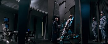 Movie still from “Demolition Man” (1993), directed by Marco Brambilla – Two men standing next to each other in a room; Wide shot, Low angle