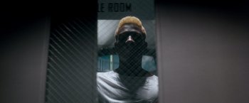 Movie still from “Demolition Man” (1993), directed by Marco Brambilla – A man with yellow hair looking through a window; Close Up shot, Low angle