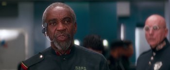 Movie still from “Demolition Man” (1993), directed by Marco Brambilla – An older man with a gray beard is looking at the camera; Close Up shot, Low angle